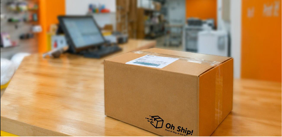 Packaged box with Oh Ship! logo on counter in Tamarac, FL shipping and print shop.