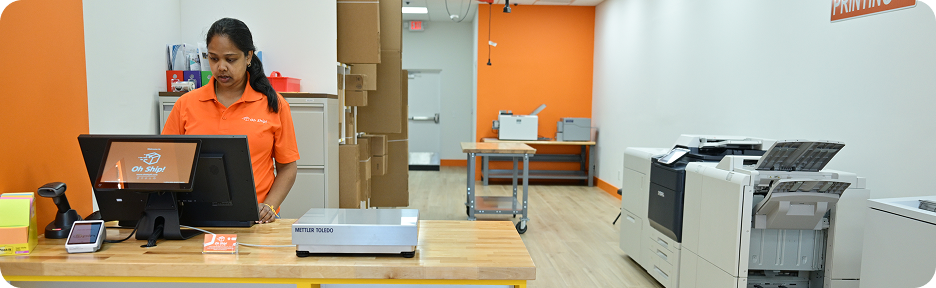 Oh Ship! employee assisting customers with printing and scanning services in Tamarac, FL.